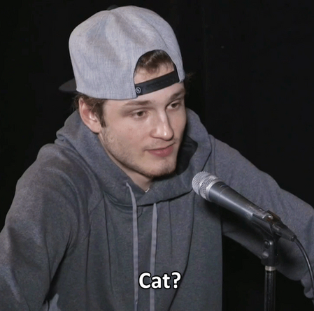 joel farabee, in a grey sweatshirt, is staring beside the camera, an odd expression on his face. the caption reads “cat?”