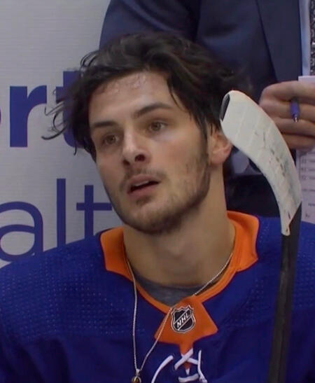 mat barzal stares to the right of the camera, his face tired and sweaty. his necklace is barely visible at the bottom of the image